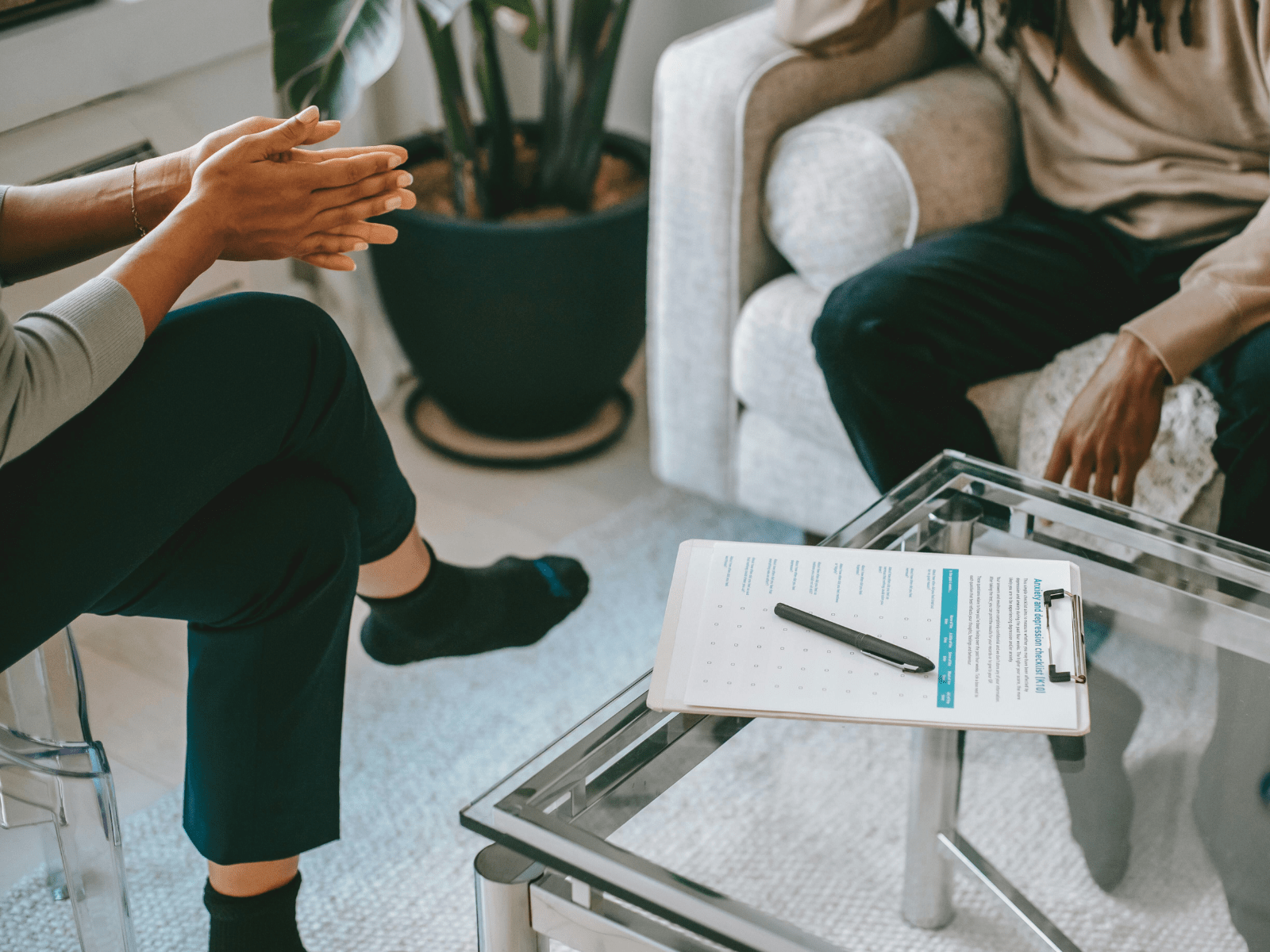 zwei Personen sitzen sich in einem Beratungsgespräch bei einer Anlaufstelle gegenüber