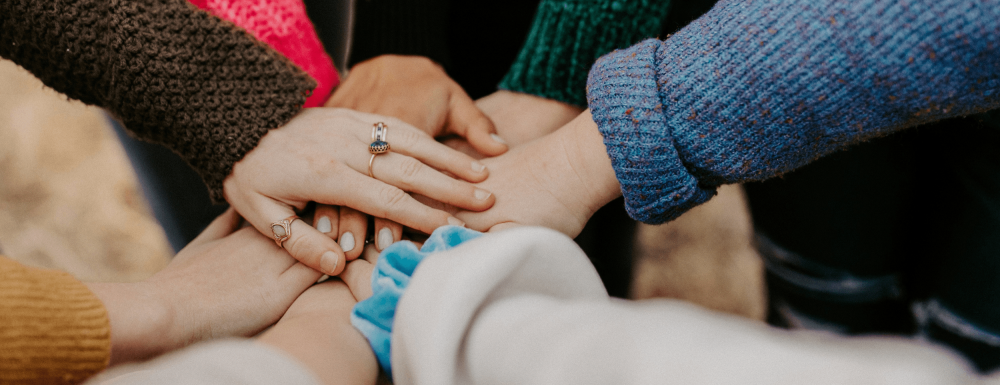 viele verschiedene Hände werden aufeinander gelegt