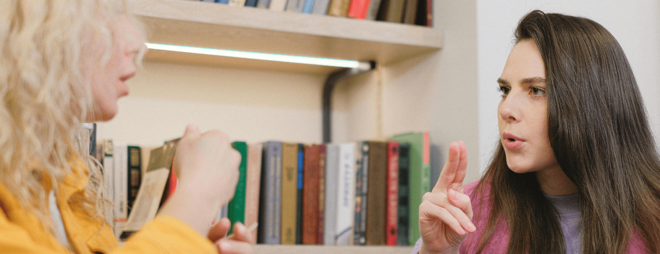 zwei Frauen gestikulieren mit ihren Händen und sprechen Gebärdensprache