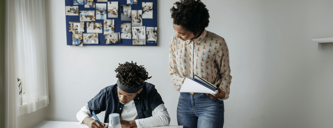 DaZ-Lehrkraft beug sich über einen DaZ-Schüler